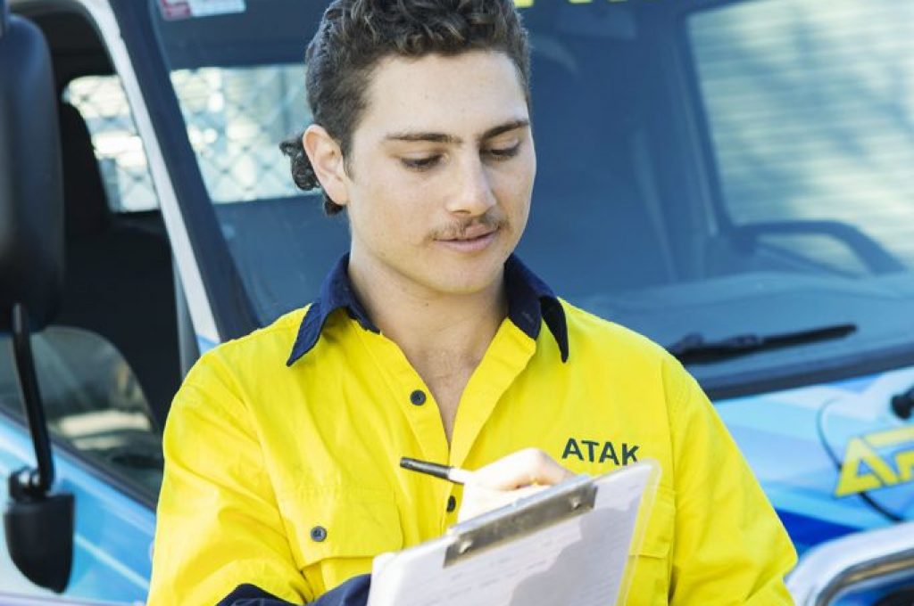 A young attack plumber with a moustache and a clipboard