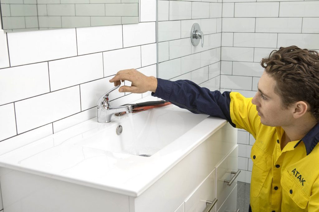 An ATAK plumber turning the faucet handle